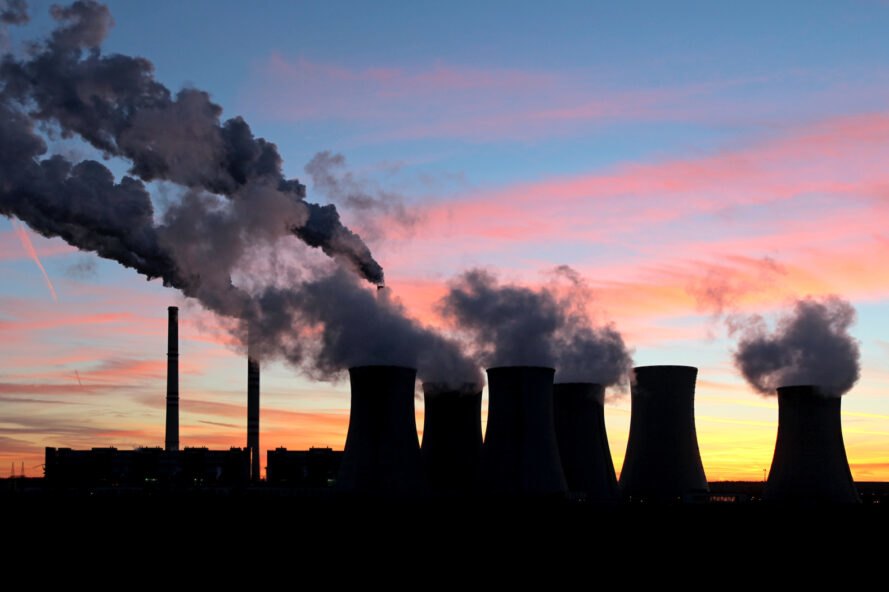 silhouettes de centrale au charbon contre un coucher de soleil