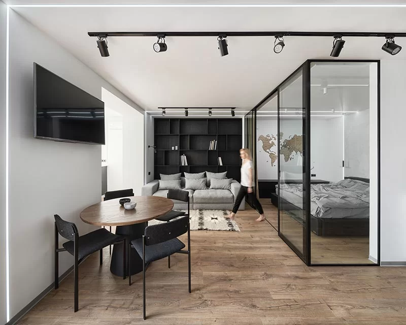 Situé directement à côté du salon de cet appartement moderne, est une chambre vitrée qui offre une séparation du reste de l'appartement, mais permet en même temps à la lumière naturelle de la fenêtre de traverser la chambre. #GlassEnclosedBedroom #ModernApartment #BedroomDesign