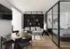 Une chambre fermée en verre crée un espace légèrement séparé à l’intérieur de ce petit appartement