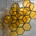 Les nids d’abeilles et les grues en origami se balancent dans des suspensions en vitrail fragiles par Lesley Green