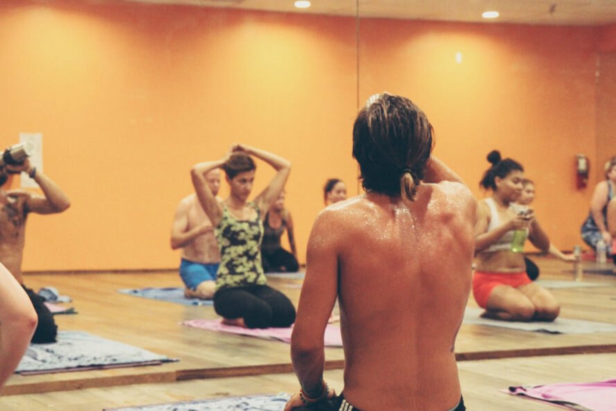 un studio de yoga chaud avec une personne en sueur au premier plan