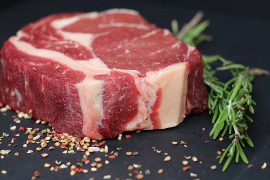 un steak entouré d'assaisonnement en vrac et un brin d'herbe