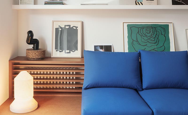 Une étagère conçue sur mesure avec une façade en lattes de bois est utilisée pour cacher le radiateur bien en vue dans cet appartement moderne. #HideRadiator #Radiator #LivingRoom