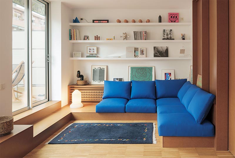 Une étagère conçue sur mesure avec une façade en lattes de bois est utilisée pour cacher le radiateur bien en vue dans cet appartement moderne. #HideRadiator #Radiator #LivingRoom
