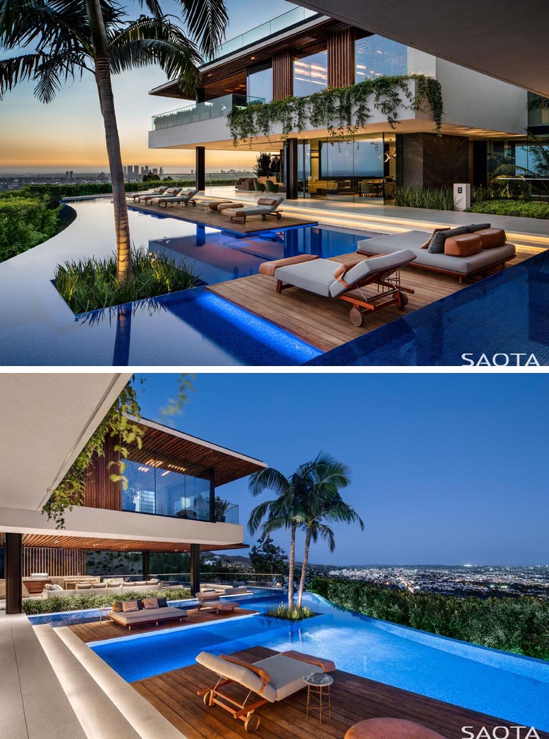 La nuit, un éclairage caché trouvé sur les marches menant aux ponts et à l'intérieur de la piscine de cette maison moderne, met en évidence les éléments de conception de la terrasse et étend la zone de divertissement de la maison. #ModernHouse #SwimmingPool #WoodDeck #PoolDesign