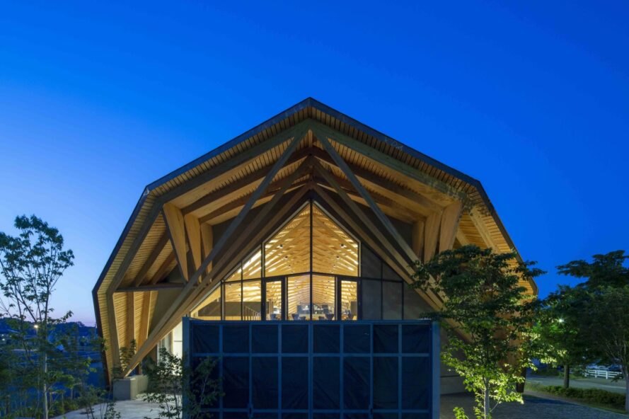 immeuble de bureaux avec toit en bois géométrique éclairé de l'intérieur la nuit