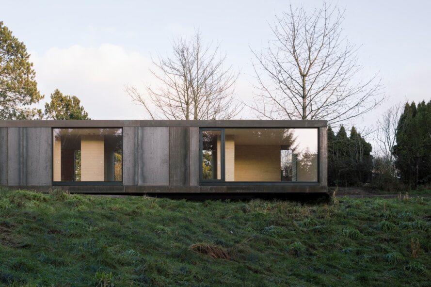 maison allongée avec de grands panneaux de verre du sol au plafond