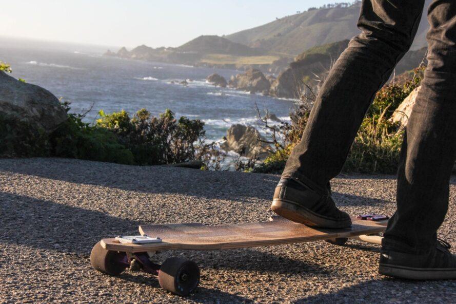 Gros plan du pied de l'homme sur une planche à roulettes en bois