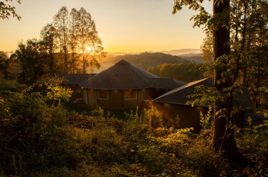 maison ronde avec montagnes et coucher de soleil en arrière-plan