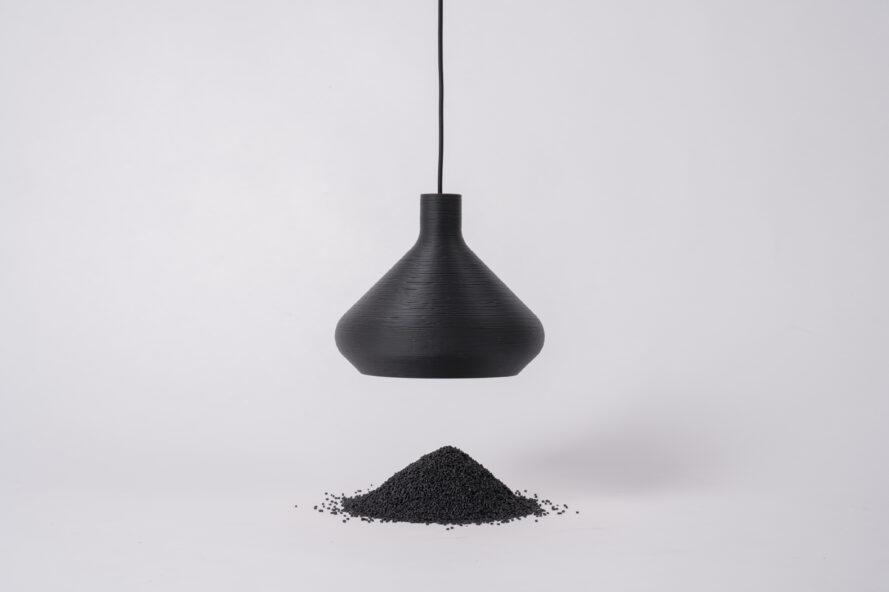 suspension noire suspendue au-dessus d'un petit tas de particules de déchets noirs