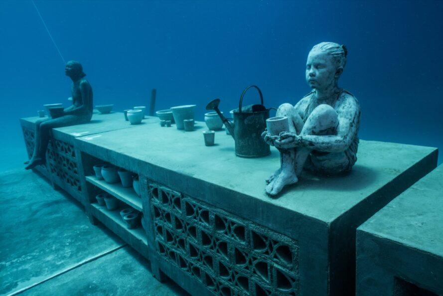 une statue sous-marine d'une personne assise sur une armoire
