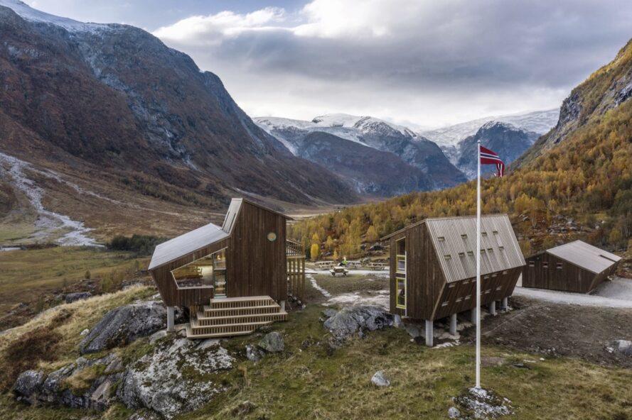 deux cabanes en bois angulaires entourées de montagnes
