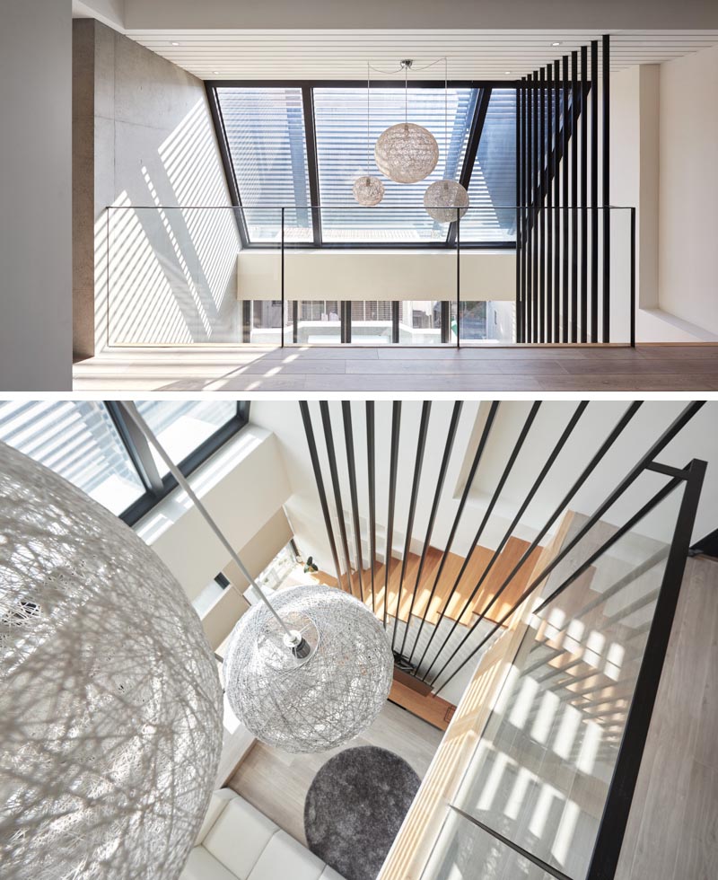 La firme de design d'intérieur INDOT a conçu un appartement moderne à Taïwan, qui présente une collection audacieuse de 12 poteaux noirs qui voyagent du salon jusqu'au haut plafond. #HighCeiling #TVMount #StairDesign