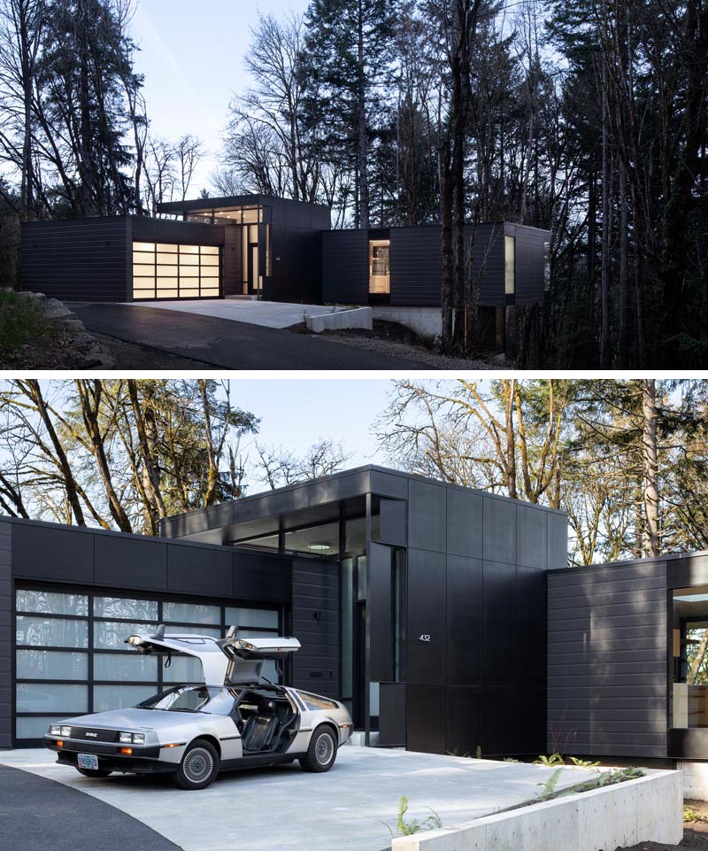 Un garage avec une porte opaque se trouve à côté de la porte d'entrée qui accueille les visiteurs à la maison. #ModernGarage #ModernHouse #BlackHouse