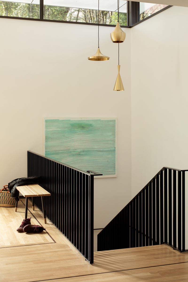 Des escaliers avec une main courante en acier noir personnalisé mènent des espaces de vie jusqu'aux chambres de cette maison moderne, #BlackHandrail #SteelHandrail #ModernHandrail