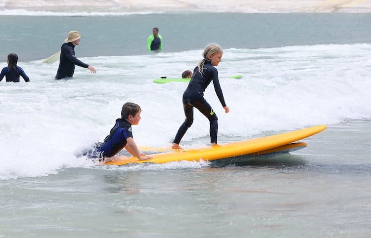 Enfants apprenant à surfer dans la piscine à vagues de Surf Lakes