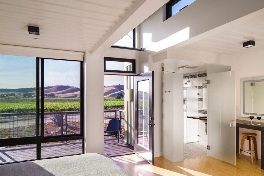intérieur blanc brillant avec de grandes fenêtres révélant une vue sur le vignoble