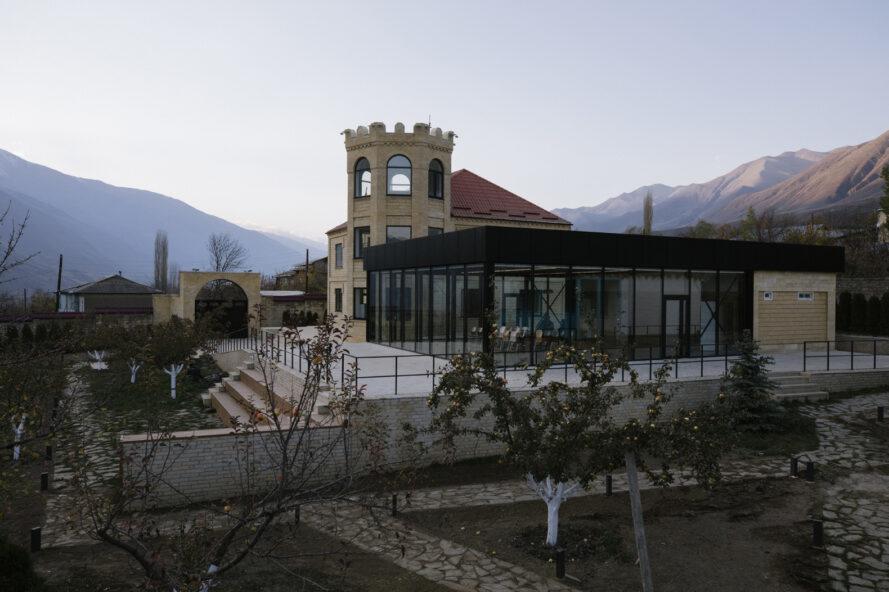 bâtiment scolaire ressemblant à un château à côté d'un bâtiment en métal noir et en verre