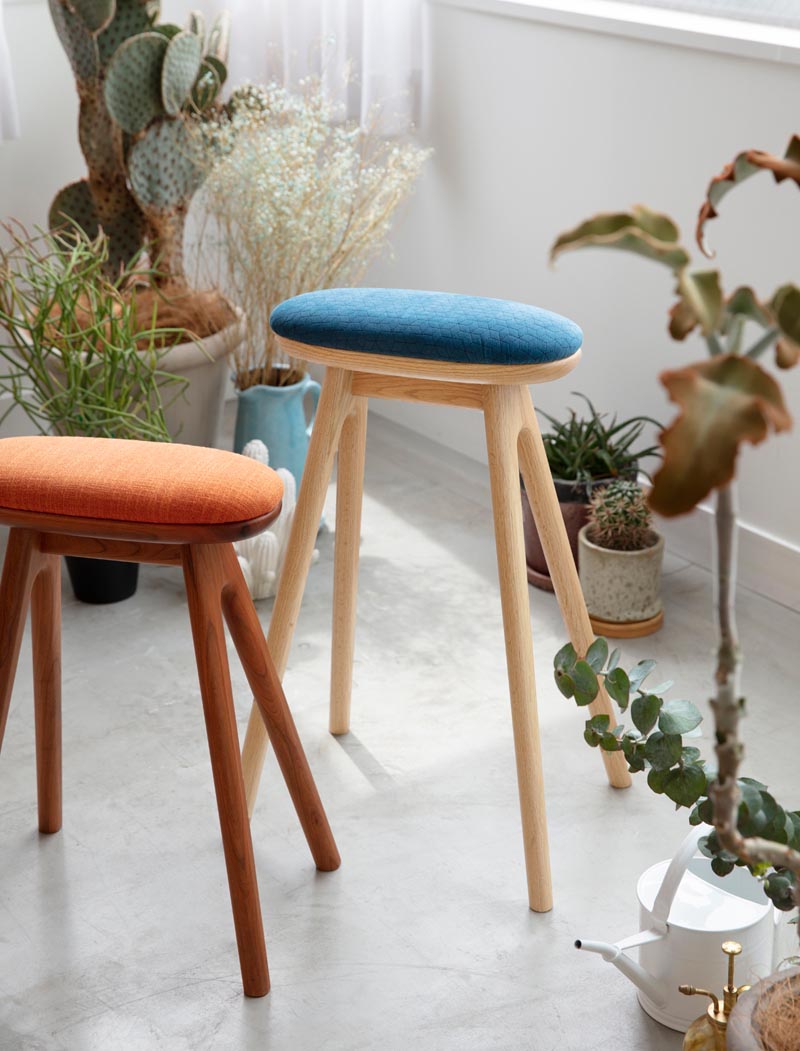 Un tabouret de cuisine en bois moderne avec un coussin rembourré.