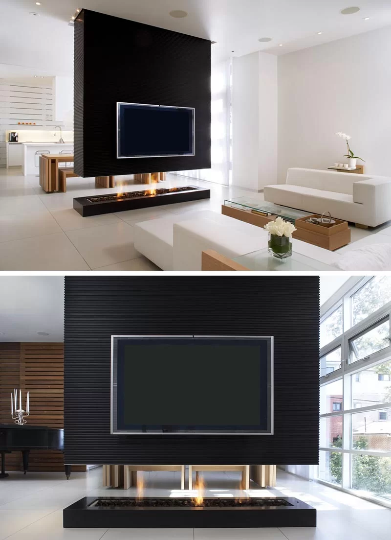 Un séparateur de pièce noir a une télévision encastrée et une cheminée transparente.