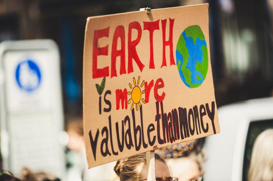 un signe de protestation lecture "La terre a plus de valeur que l'argent"