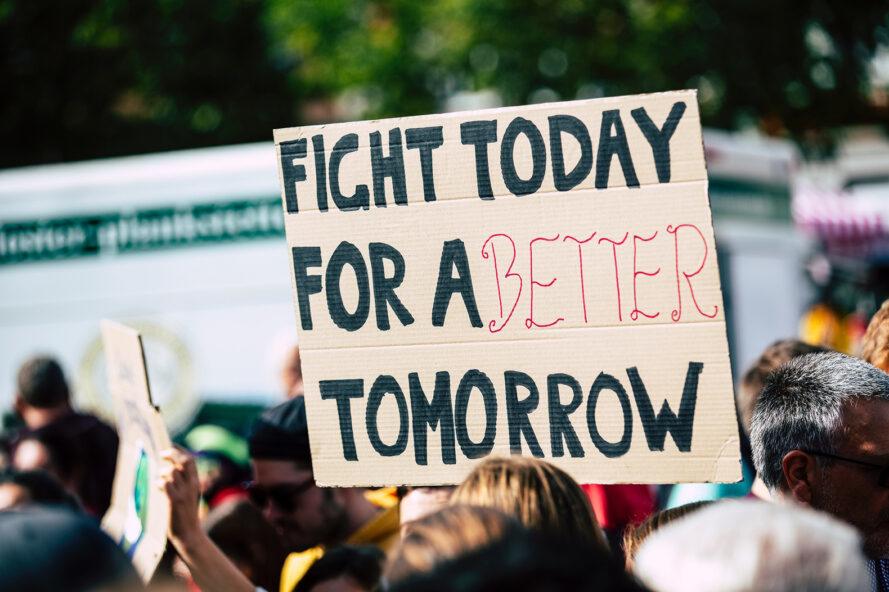 un signe de protestation lecture "Combattez aujourd'hui pour un avenir meilleur"