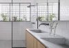 Voici un aperçu d’une salle de bain lumineuse avec une palette de matériaux en bois, granit et accents noirs