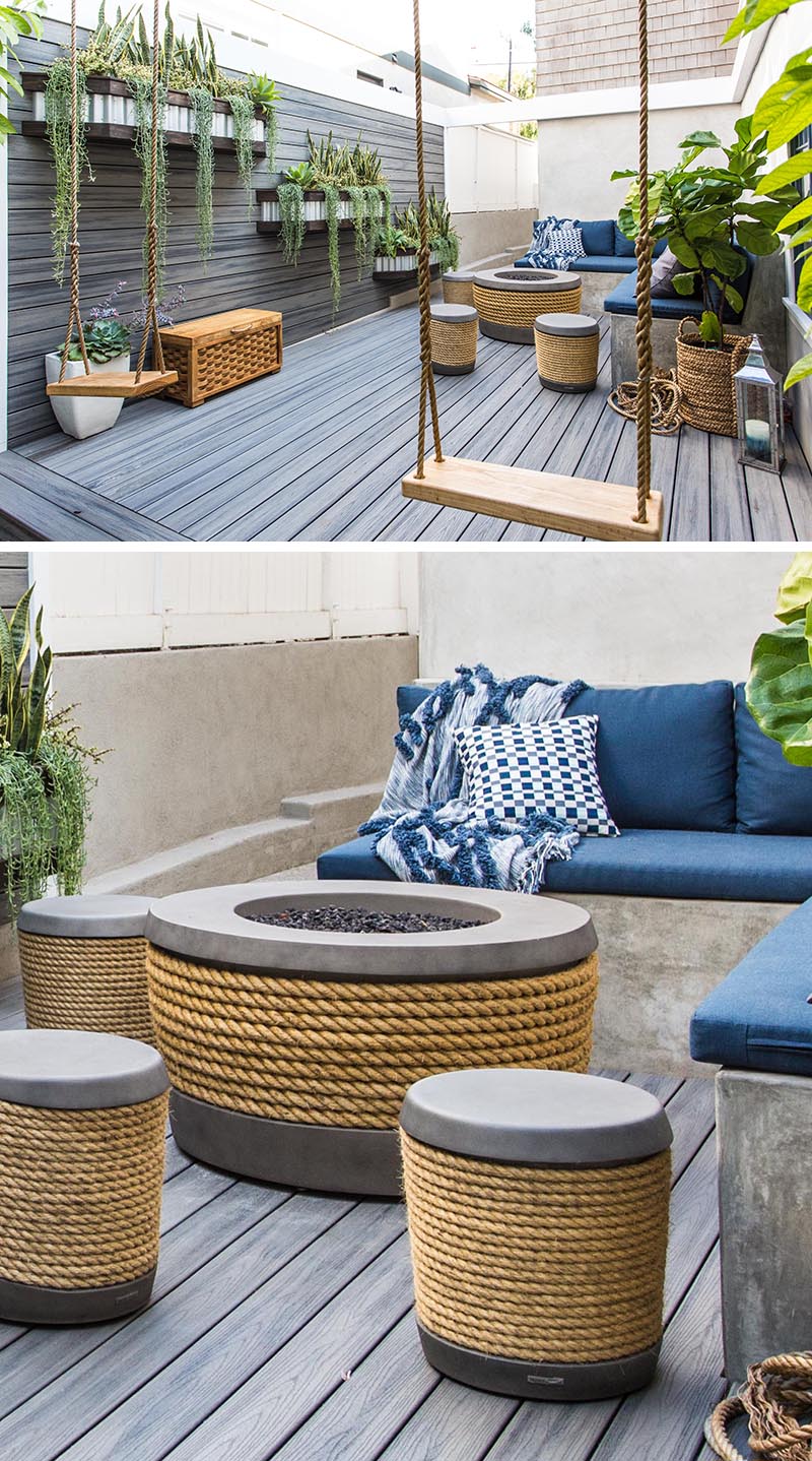 Cette cour latérale moderne comprend un mur en bois avec des jardinières, ainsi qu'une terrasse, tous deux construits en matériau Timber Tech. Dans le coin, il y a un banc en forme de L avec des tabourets, une paire de balançoires et une table de feu en béton et en corde. #SideYard #LandscapeDesign #ModernOutdoorSpace