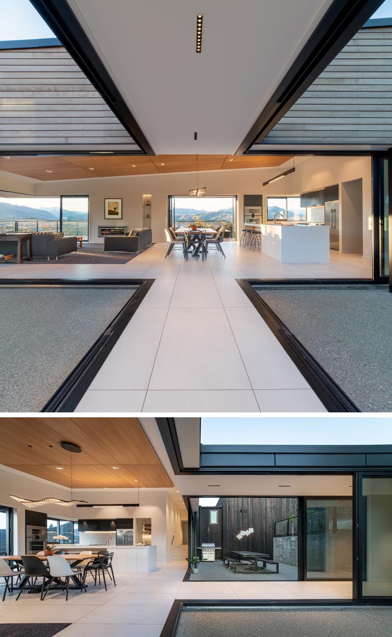 Les murs de verre rétractables relient les espaces intérieurs de cette maison avec une salle à manger en plein air et un patio.