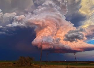 Un nuage de couleur bonbon plane sur un paysage de l’ouest du Texas au milieu d’un orage